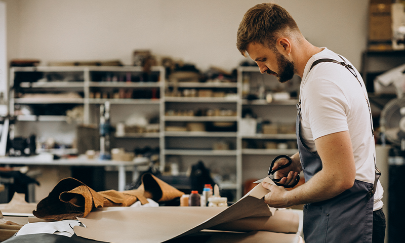 man tailor working with leather fabric